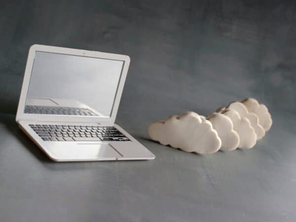 Cloud computing concept. Laptop and white clouds.