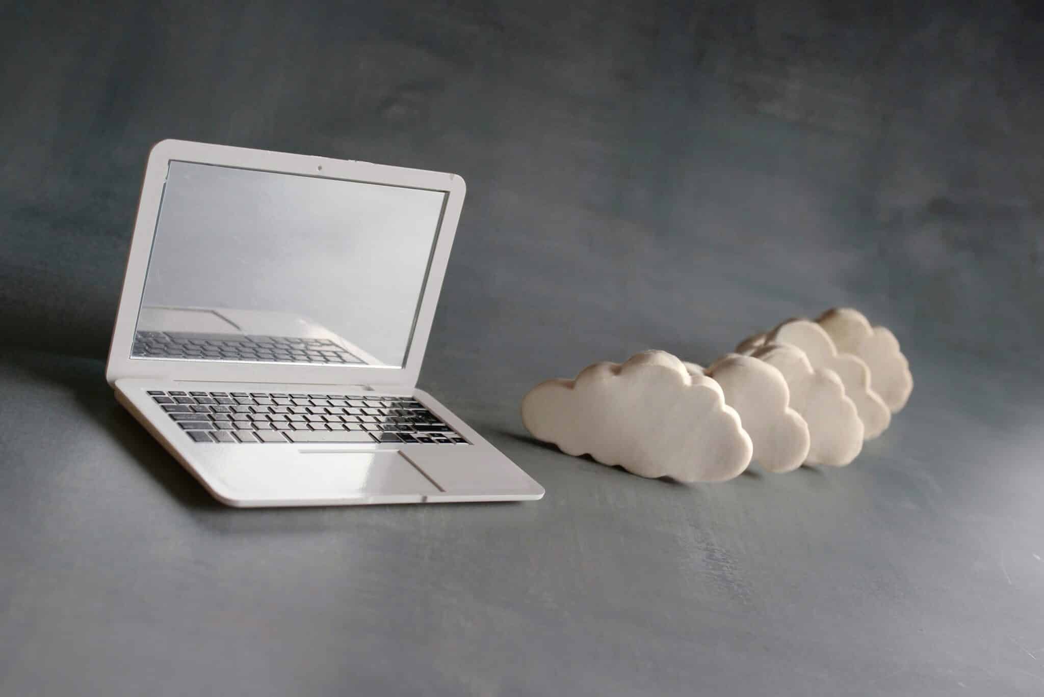 Cloud computing concept. Laptop and white clouds.